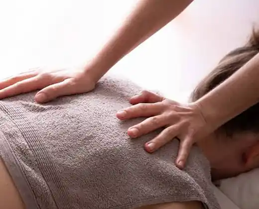 Hot towel finish after a home massage in Hyderabad — warm towel pressed over the back